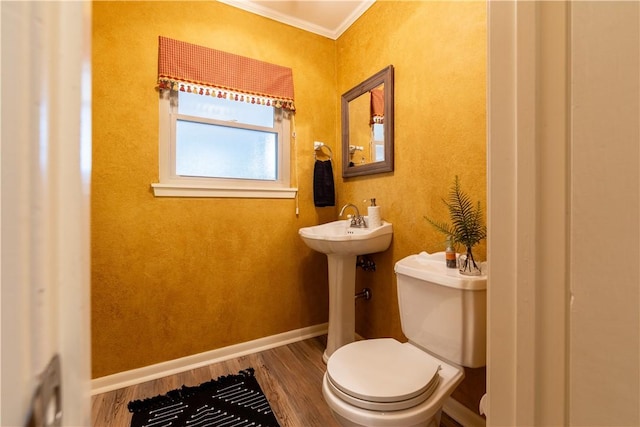 bathroom with sink, wood-type flooring, ornamental molding, and toilet