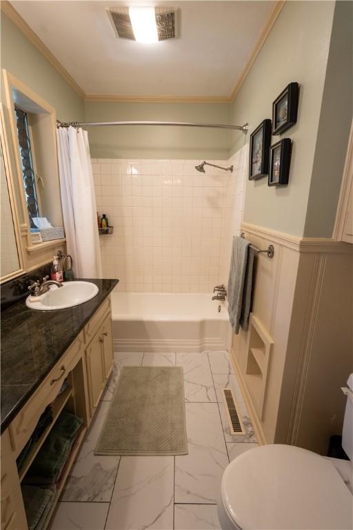 full bathroom with crown molding, vanity, toilet, and shower / tub combo