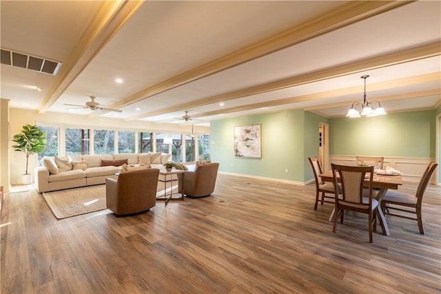 living room with ceiling fan with notable chandelier, hardwood / wood-style floors, ornamental molding, and beam ceiling