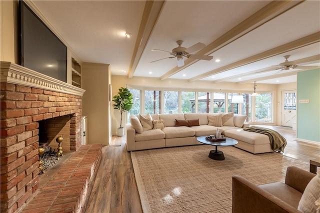 living room featuring hardwood / wood-style flooring, beam ceiling, ceiling fan, and a fireplace