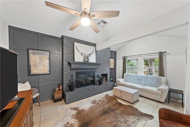 tiled living room featuring vaulted ceiling with beams, ceiling fan, and a fireplace