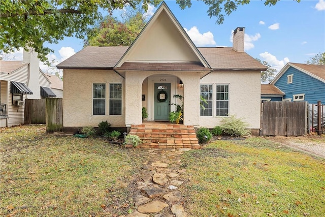 view of front of house with cooling unit and a front lawn