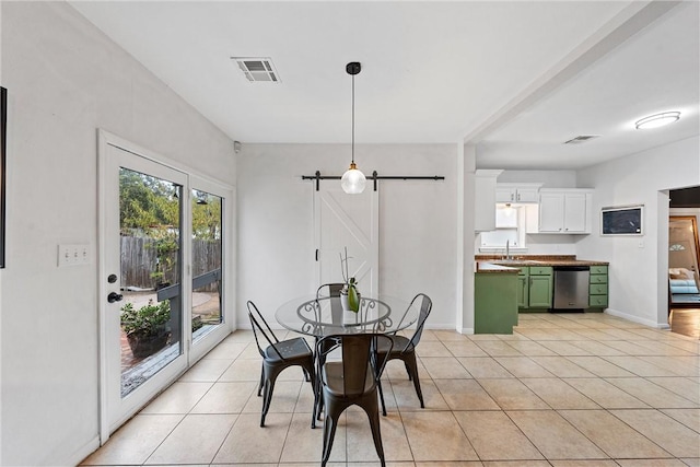 tiled dining area featuring a barn door and sink