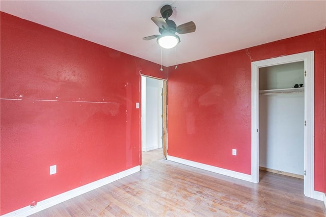 unfurnished bedroom with ceiling fan, a closet, and light hardwood / wood-style flooring