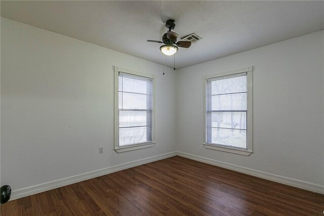 spare room featuring ceiling fan, hardwood / wood-style flooring, and a healthy amount of sunlight