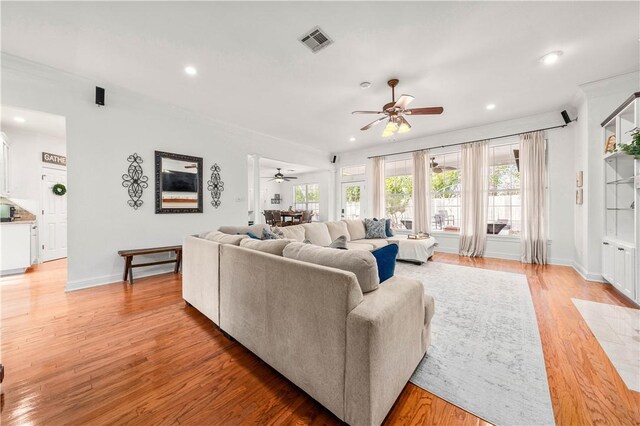 dining space with sink, crown molding, ceiling fan, light wood-type flooring, and ornate columns