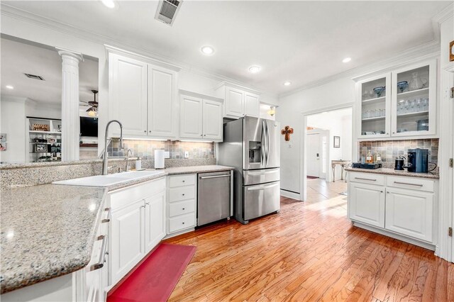 kitchen featuring sink, ceiling fan, light wood-type flooring, appliances with stainless steel finishes, and white cabinetry