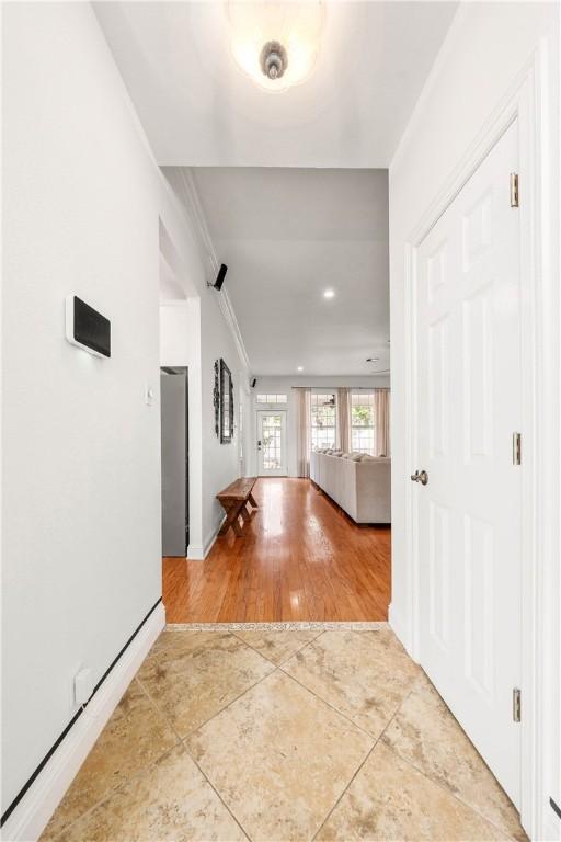 living room with ceiling fan, ornamental molding, plenty of natural light, and light wood-type flooring