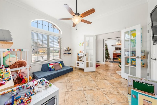 recreation room with ceiling fan, light tile patterned floors, crown molding, and french doors