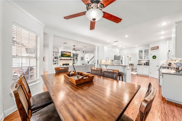 living room with ceiling fan, ornamental molding, and light hardwood / wood-style flooring