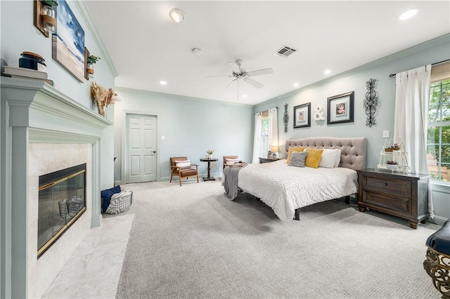 bedroom with ensuite bathroom, crown molding, ceiling fan, light colored carpet, and a fireplace