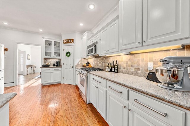 kitchen with white cabinetry, sink, stainless steel appliances, and light wood-type flooring