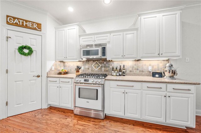 kitchen featuring white cabinetry, light hardwood / wood-style flooring, crown molding, and appliances with stainless steel finishes