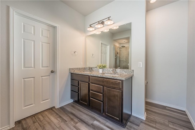 bathroom featuring hardwood / wood-style flooring, vanity, and a shower with shower door