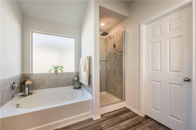 bathroom with hardwood / wood-style flooring and independent shower and bath