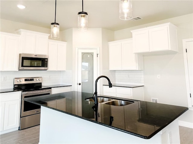 kitchen featuring white cabinetry, a center island with sink, hanging light fixtures, and appliances with stainless steel finishes