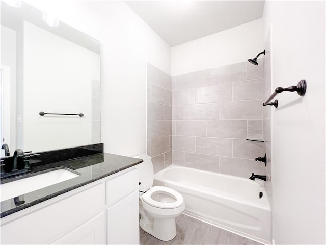 full bathroom featuring toilet, hardwood / wood-style floors, vanity, and tiled shower / bath