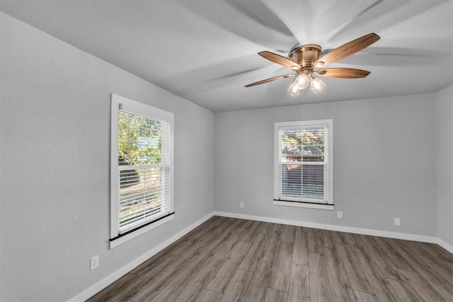 spare room with hardwood / wood-style floors and ceiling fan