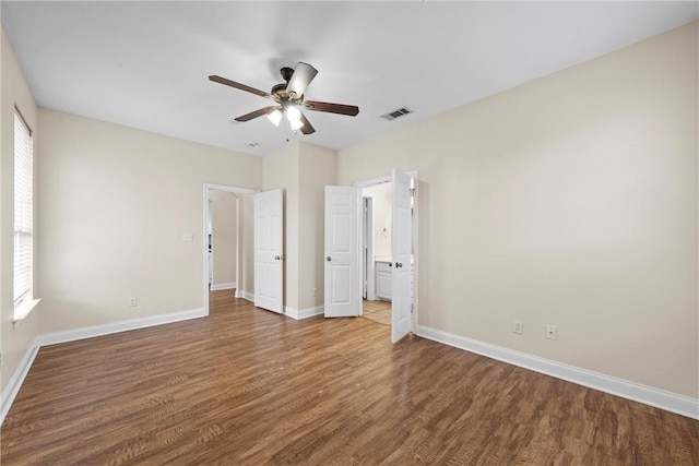 unfurnished bedroom with ceiling fan, connected bathroom, and hardwood / wood-style floors