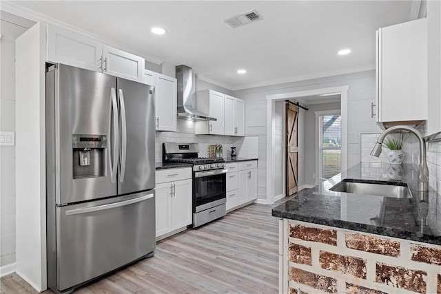 kitchen featuring a barn door, appliances with stainless steel finishes, sink, and white cabinets