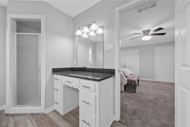 bathroom with hardwood / wood-style flooring, ceiling fan, an enclosed shower, vanity, and ornamental molding