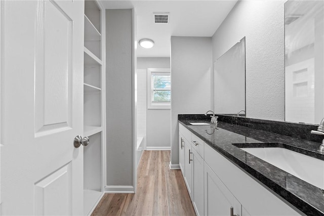 bathroom with vanity, bathing tub / shower combination, and hardwood / wood-style floors