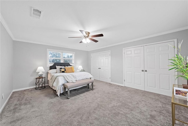 carpeted bedroom with ceiling fan, crown molding, and multiple closets