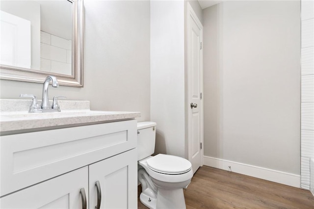 bathroom with vanity, hardwood / wood-style flooring, and toilet