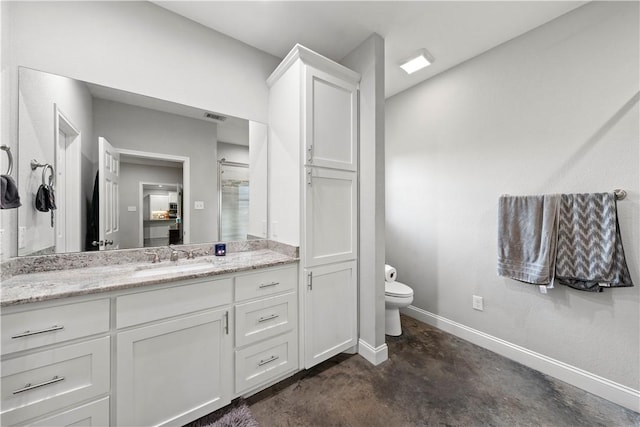 bathroom with vanity, concrete floors, and toilet