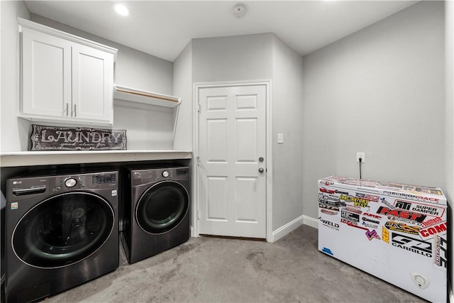 clothes washing area featuring cabinets and separate washer and dryer