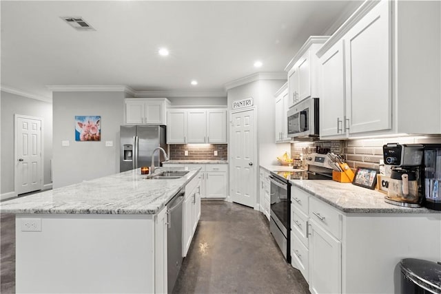 kitchen with stainless steel appliances, white cabinetry, sink, and an island with sink