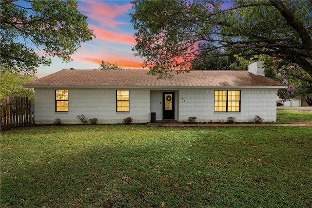 ranch-style home with a lawn