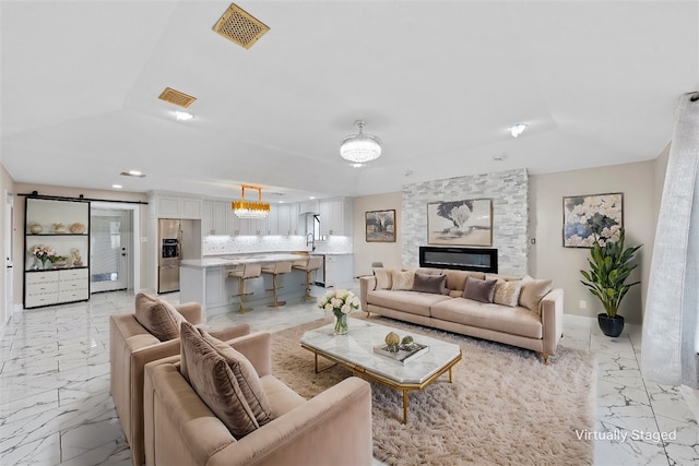 living room featuring a stone fireplace and sink