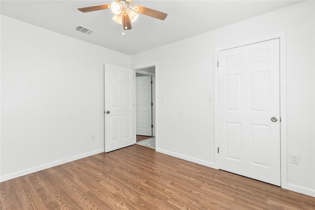 unfurnished bedroom with a textured ceiling, light hardwood / wood-style flooring, and ceiling fan