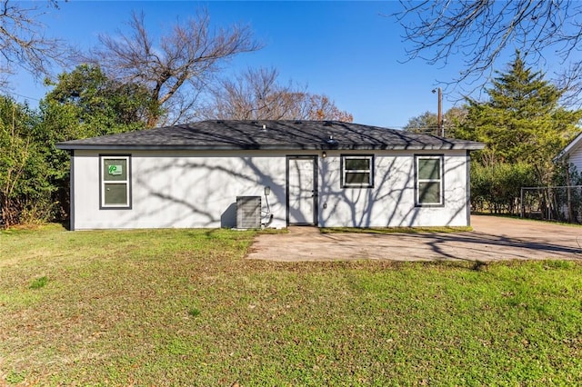 back of house with a lawn and a patio