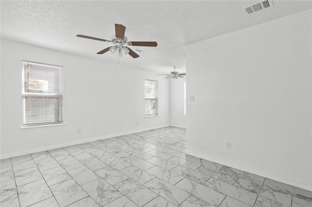 empty room featuring ceiling fan and a textured ceiling