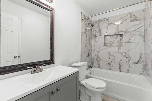 full bathroom featuring vanity, tiled shower / bath combo, a textured ceiling, and toilet