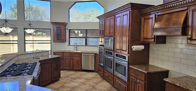 kitchen featuring custom exhaust hood, a healthy amount of sunlight, appliances with stainless steel finishes, and sink