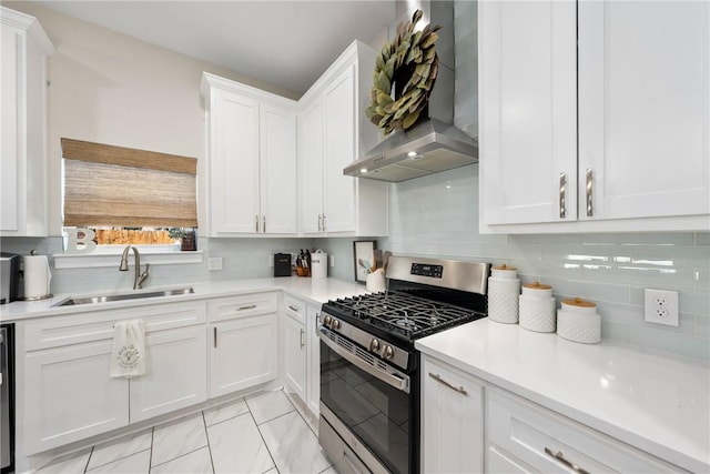 kitchen featuring sink, white cabinets, decorative backsplash, stainless steel range with gas cooktop, and wall chimney exhaust hood