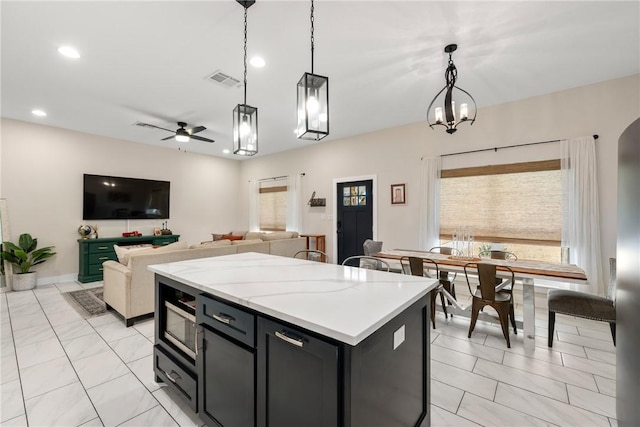 kitchen with a kitchen island, pendant lighting, ceiling fan, and light tile patterned floors