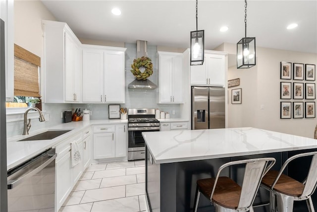 kitchen with a kitchen island, appliances with stainless steel finishes, sink, and white cabinets