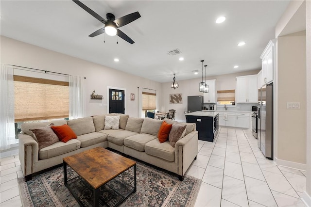 living room featuring ceiling fan and sink