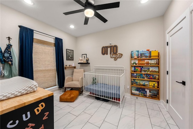 bedroom with a nursery area and ceiling fan