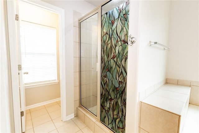 bathroom with baseboards, a shower stall, and tile patterned flooring