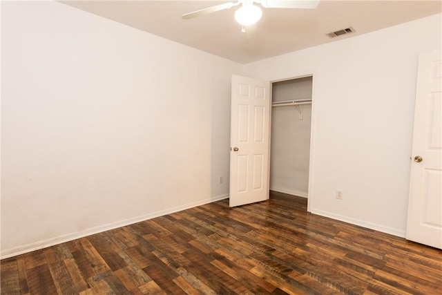 unfurnished bedroom featuring ceiling fan, visible vents, baseboards, and dark wood-style floors