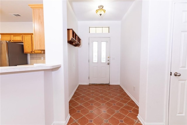 foyer entrance with visible vents and baseboards