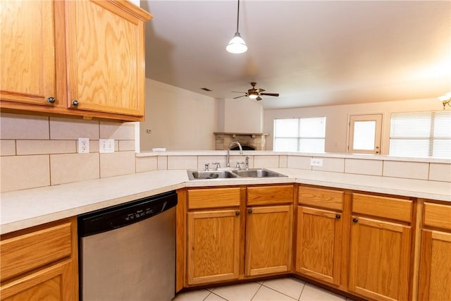 kitchen with stainless steel dishwasher, light countertops, backsplash, and a sink