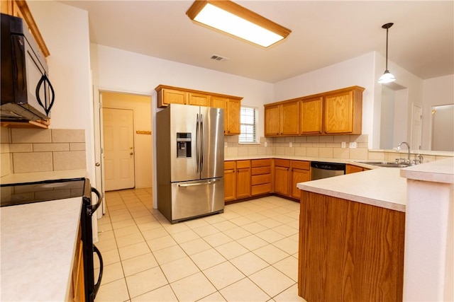 kitchen with tasteful backsplash, visible vents, light countertops, stainless steel appliances, and a sink