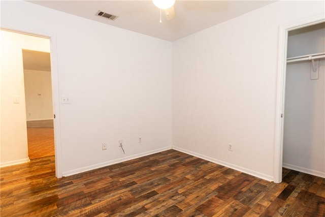 unfurnished bedroom with dark wood-style floors, visible vents, and baseboards