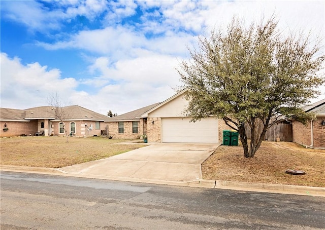 ranch-style house with concrete driveway, a garage, brick siding, and a front yard